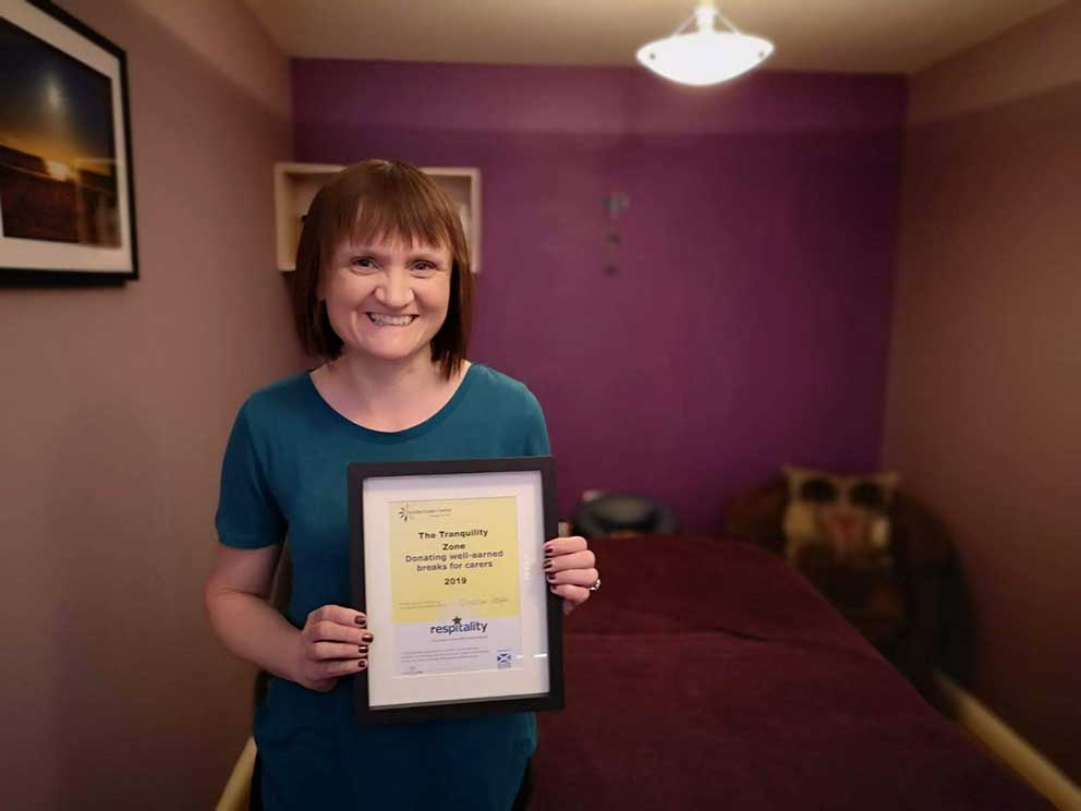 Jenny with certificate recognising the donation of services by The Tranquility Zone by Dundee Carers Centre